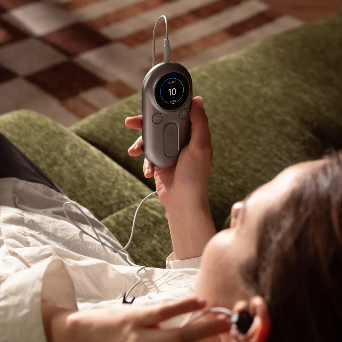Woman relaxing in bed while using an ear-worn vagus nerve stimulation device