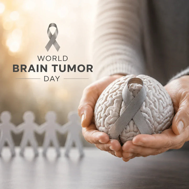 grey awareness ribbon on a brain model held in hands for world brain tumor day