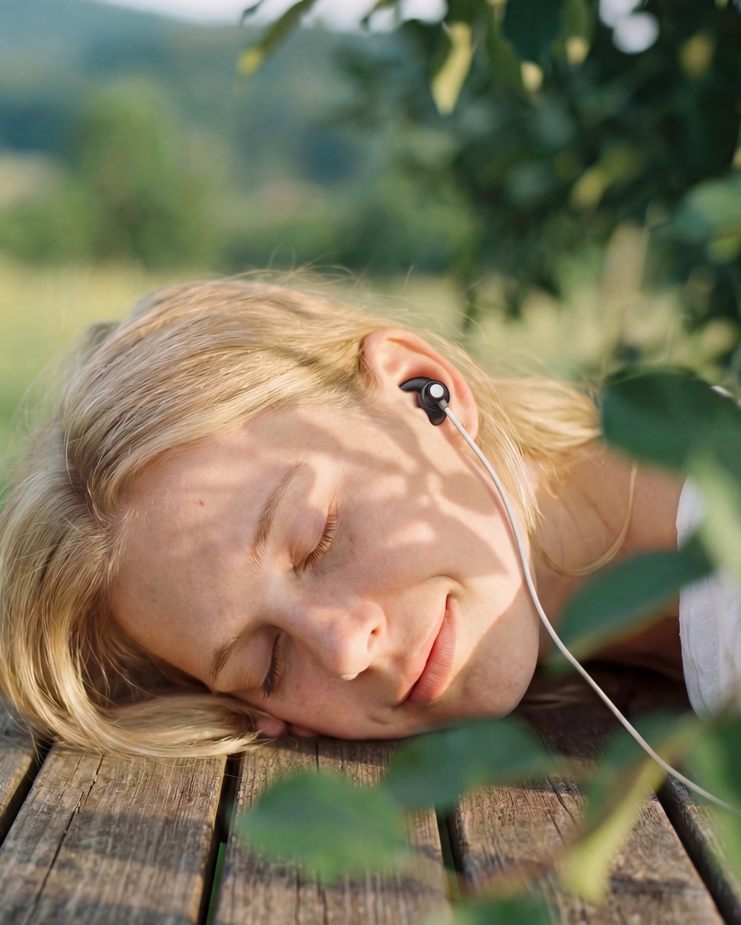 person relaxing outdoors while using an ear vagus nerve stimulation device