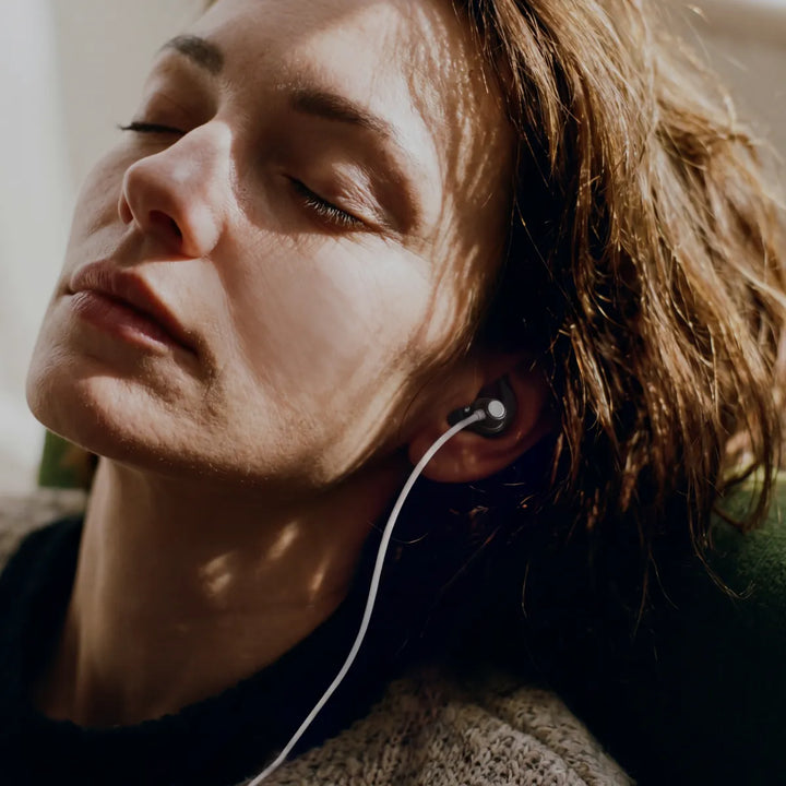 woman relaxing with an ear stimulation device