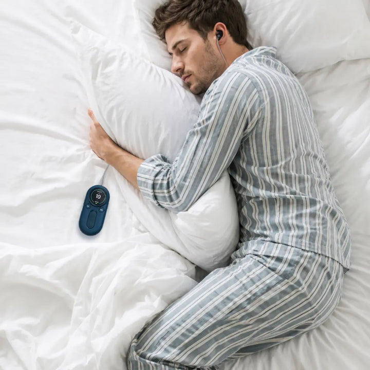 Person sleeping in bed with a vagus nerve stimulation device nearby as part of a nighttime wellness routine