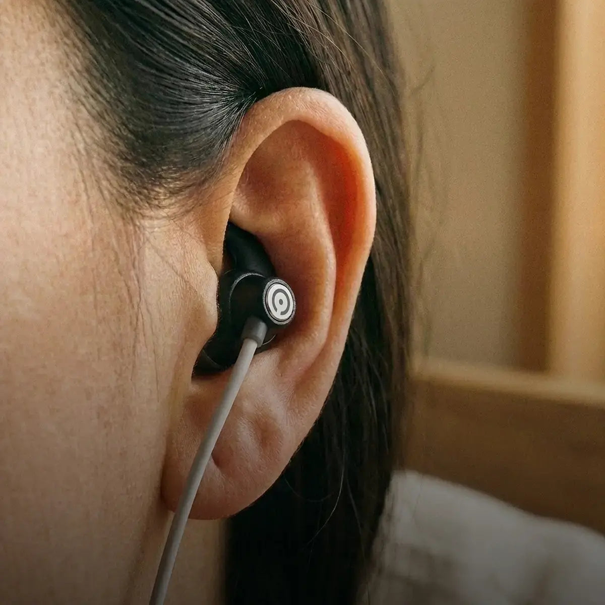 Close-up of an ear-worn vagus nerve stimulation device used for a non-invasive wellness routine
