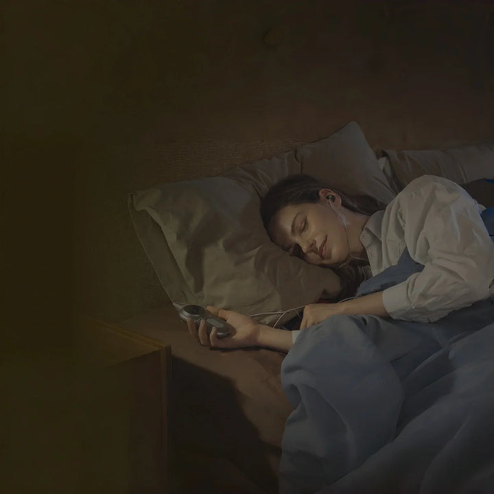 woman using an ear-worn vagus nerve stimulation device while sleeping