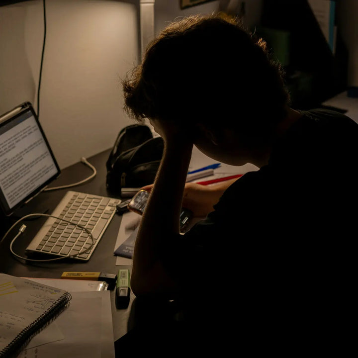A young professional struggling to focus while working at a desk in a modern office environment